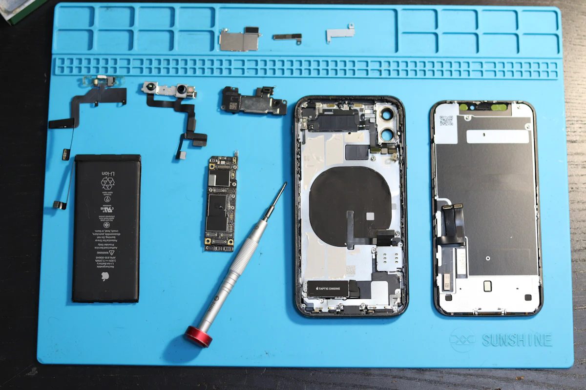 Phone components laid out on a repair mat